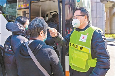党员协助公交车司机为乘客测体温。.jpg