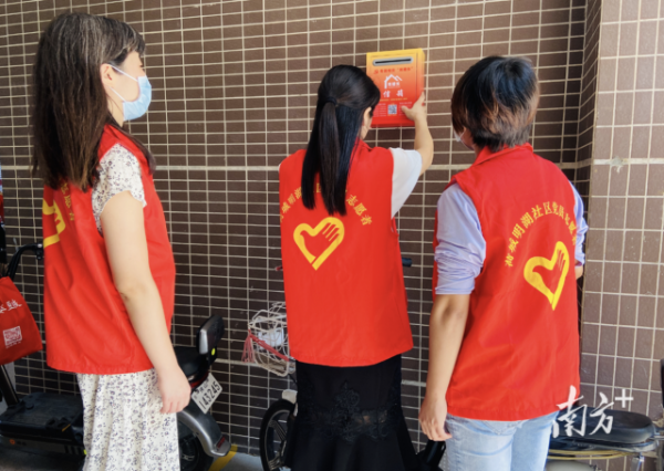 高明实施“双楼长”机制，探索基层治理新路。图为社区工作人员在楼宇出入口安装“双楼长”信箱。 荷城街道供图