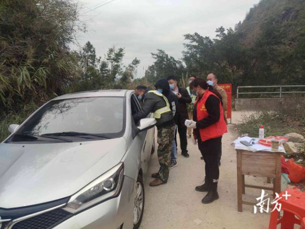 思贺镇党员干部在疫情防控检查站为过往车辆人员进行检测。 通讯员 供图
