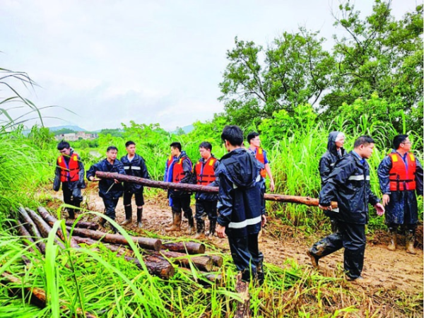 博罗县龙华镇党员干部搬运木头封堵堤坝缺口。市委组织部提供