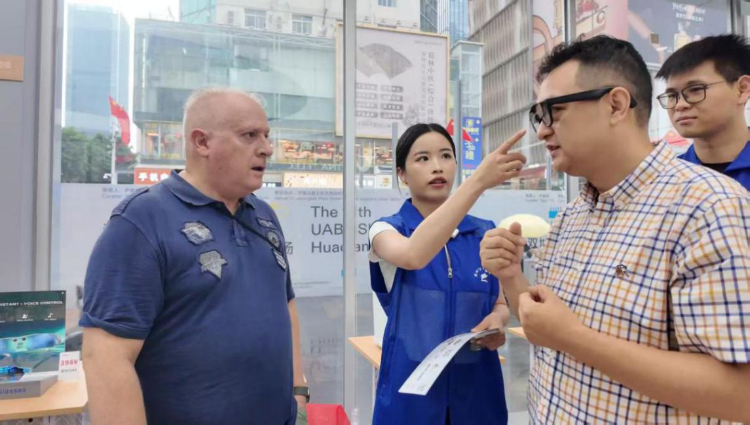 随着APEC会议临近，各区各单位公务员纷纷加入服务队，身着蓝马甲走街串巷，他们忙碌的身影正成为这座城市一道道靓丽的风景线。如福田区公务员服务队进驻华强北全球人工智能应用场景中心，化身“招商服务员”“产品推荐官”，在市场一线为外籍人士提供外语导购、产品体验、下单发货一站式服务。.jpeg
